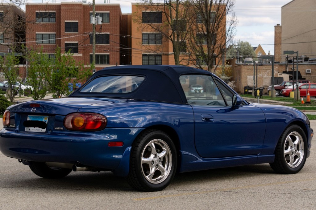 The rear 3/4 view of a blue 1999 Mazda MX-5 Miata 10th Anniversary Edition in a parking lot