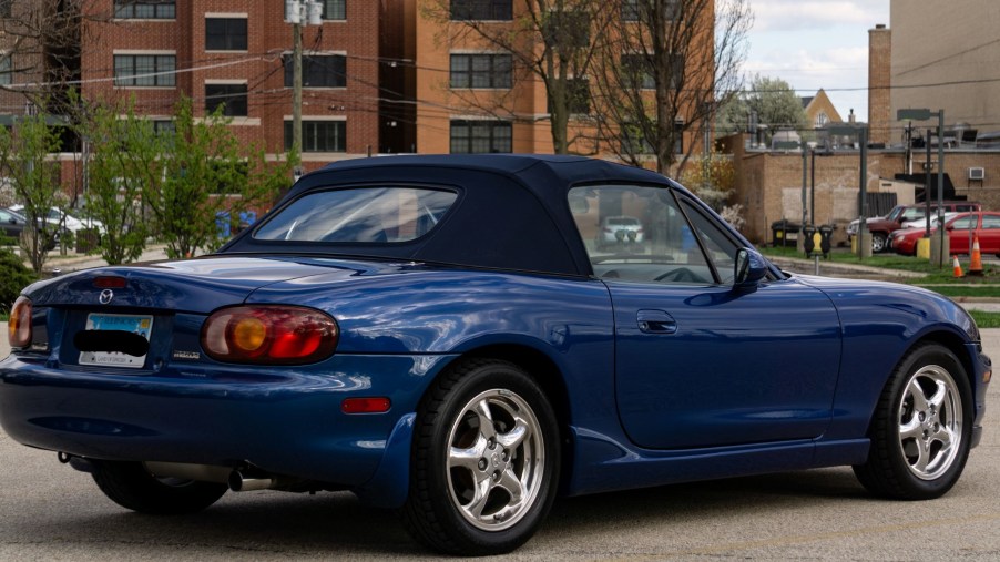 The rear 3/4 view of a blue 1999 Mazda MX-5 Miata 10th Anniversary Edition in a parking lot