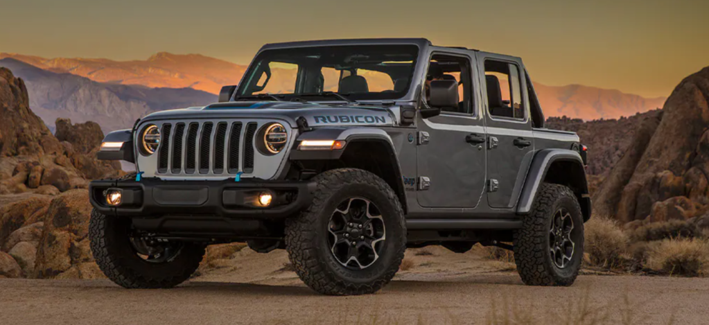 The 2021 Jeep Wrangler 4xe plug-in hybrid model parked in a desert and surrounded by rocks
