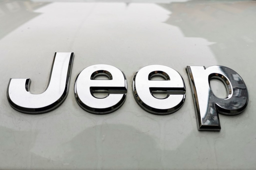 Close up of a chrome Jeep logo on a silver car.