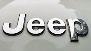 Close up of a chrome Jeep logo on a silver car.