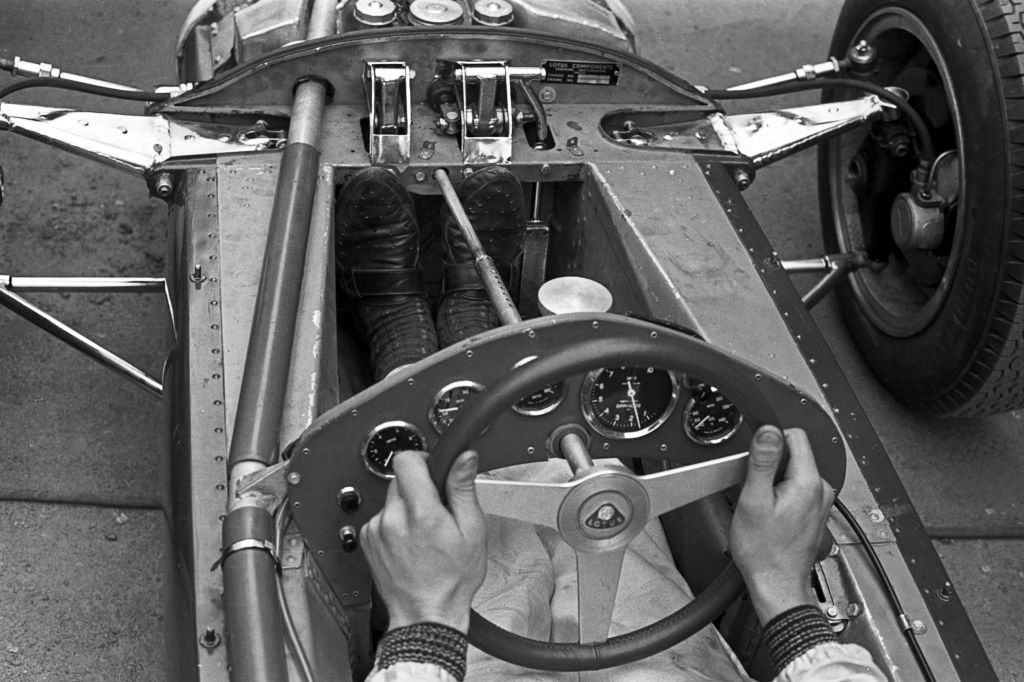 Jim Clark with his feet on two of the Lotus 25 F1 car's three pedals at the 1962 Grand Prix of Belgium