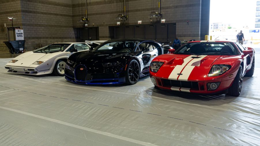 A white Lamborghini Countach 5000 S, black-and-blue Bugatti Chiron, and red-and-white Ford GT at the 2021 Chicago Auto Show