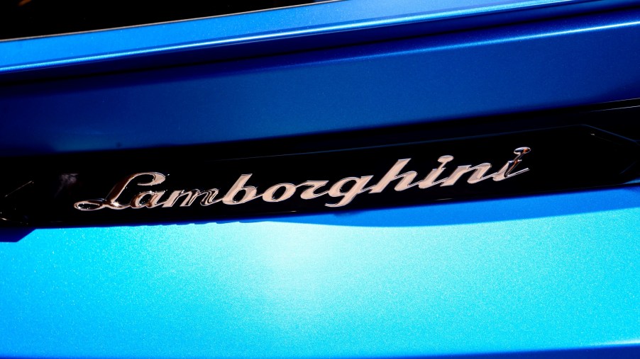 Close shot of the back of a blue Lamborghini displaying the full name of the car.