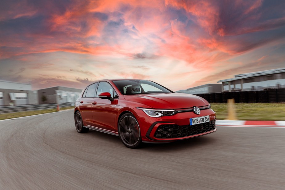 A red 2022 Volkswagen GTI on a racetrack at sunset in Germany