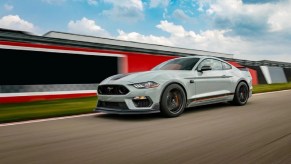 A light-colored 2021 Ford Mach-E races along a track.