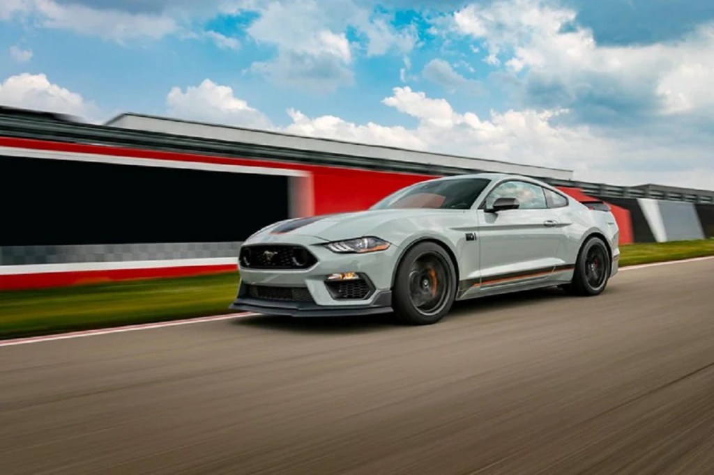 A light-colored 2021 Ford Mach-E races along a track. Ford's new gasoline perfume is inspired by the Mach-E.