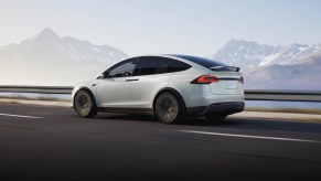 A white 2021 Tesla Model X drives down a highway.