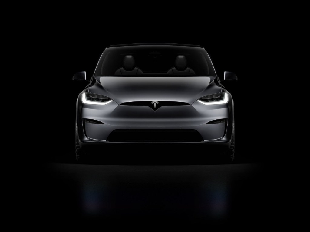 A dark gray 2021 Tesla Model X against a black background.