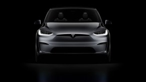 A dark gray 2021 Tesla Model X against a black background.