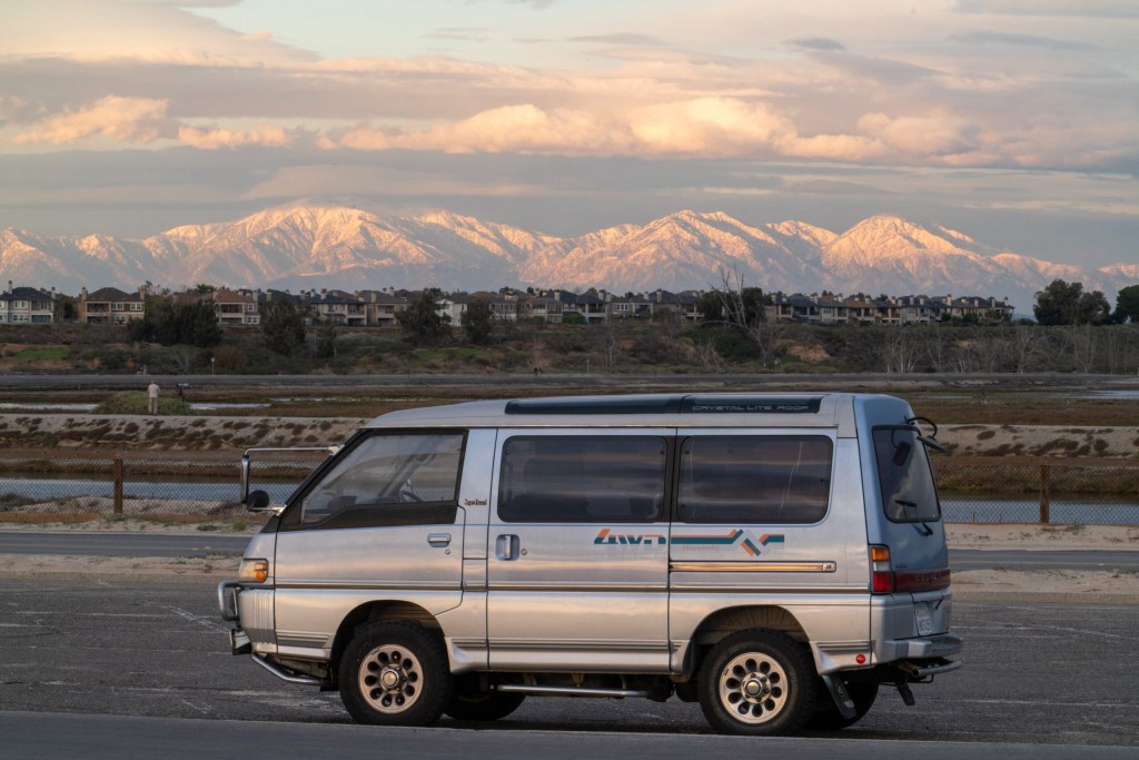 This 1992 Mitsubishi Delica parked in front of a So Cal Moutnain range is a vintage JDM camper van for the ages.