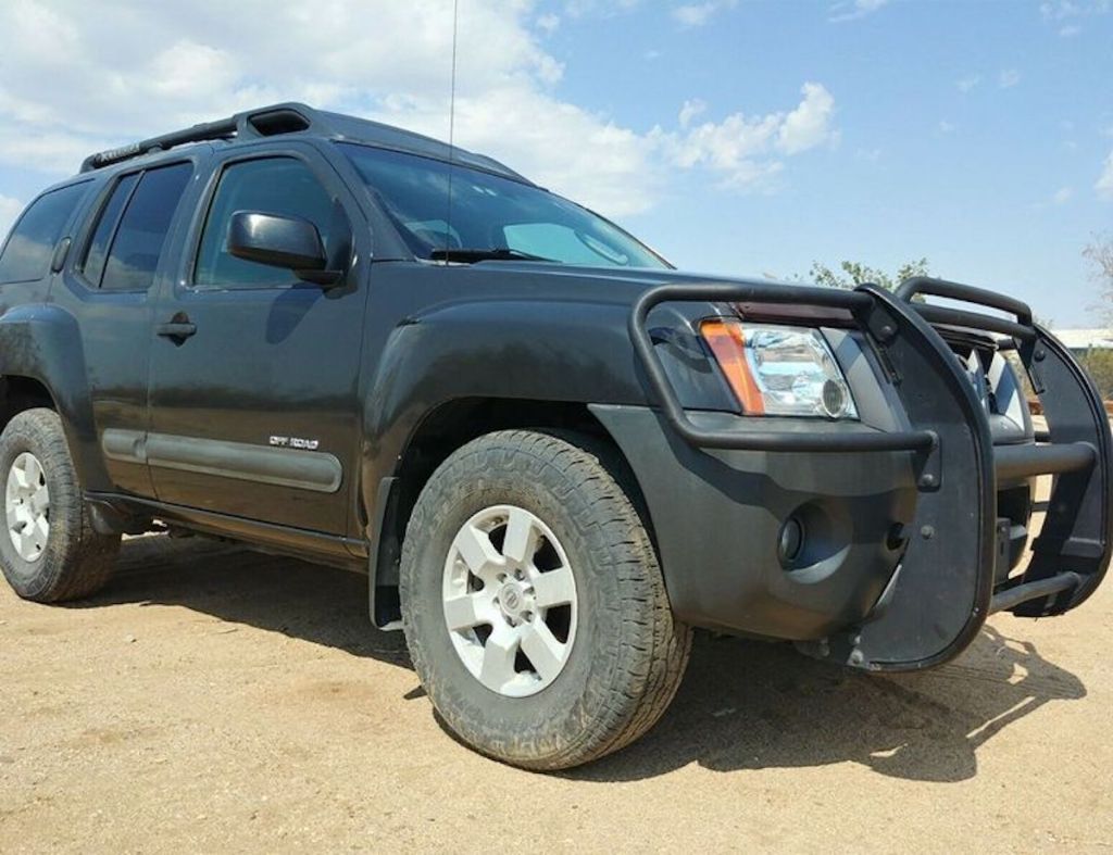 Nissan Xterra parked in the sand and happens to be one of the cheapest and best SUVs for someone looking for their first car.