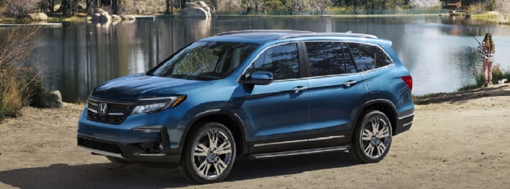 A blue 2021 Honda Pilot parked at a lake.