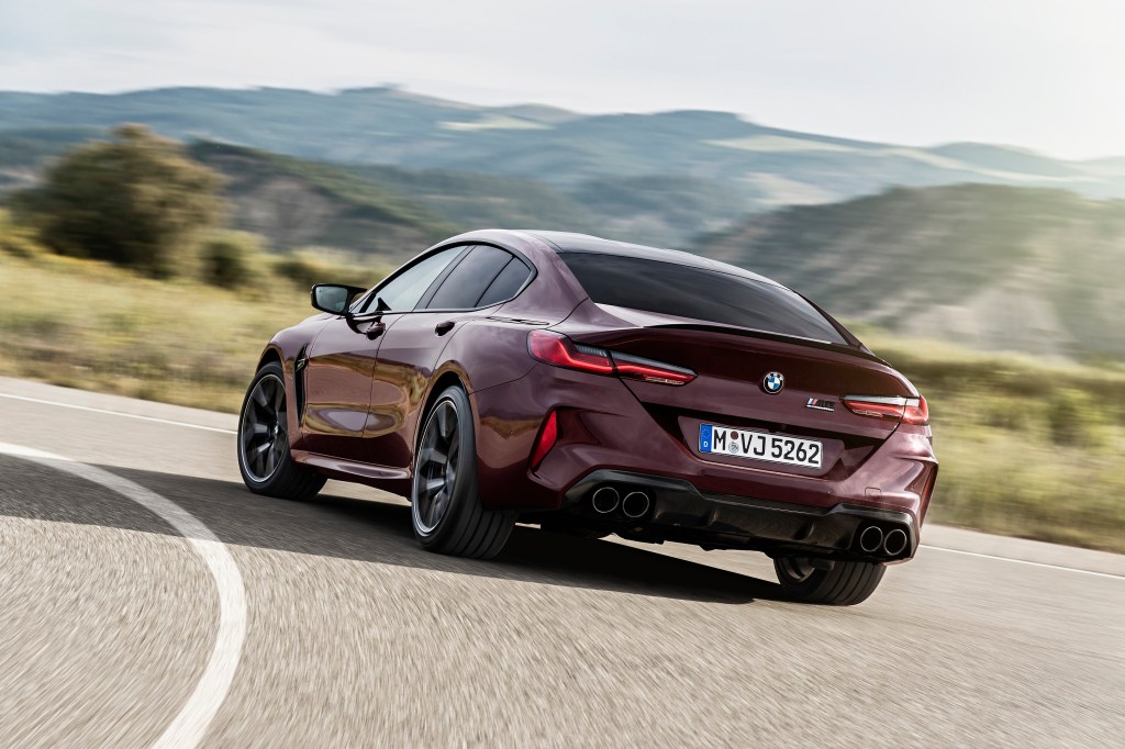 The rear of a maroon BMW M8 GC on a twisty section of road