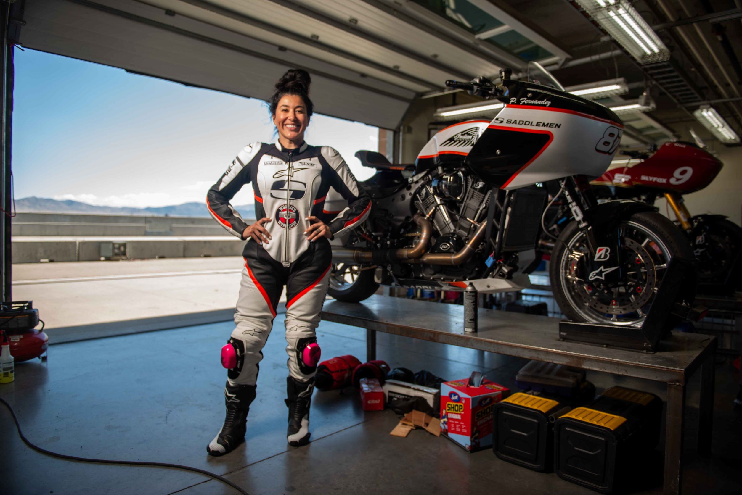Patricia Fernandez with her Saddlemen King of the Baggers Indian Challenger in a track-side garage