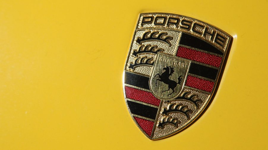 A Porsche logo badge on a yellow car