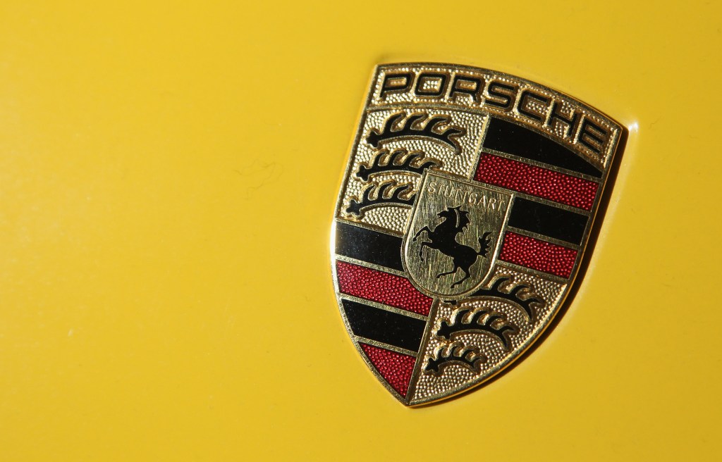 A Porsche logo badge on a yellow car