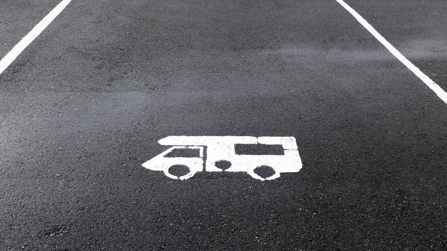 A blacktopped parking space with a white stencil sprayed representation of an RV.
