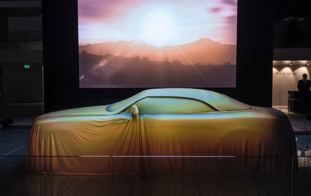 The Rolls-Royce Dawn convertible under a sheet at its debut