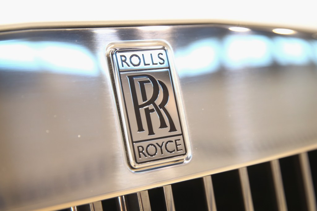 The Rolls-Royce emblem stamped into a chrome badge on a chrome grille