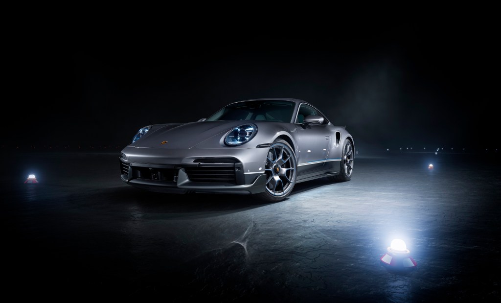 A silver Porsche 911 Turbo S surrounded by lights at a photoshoot