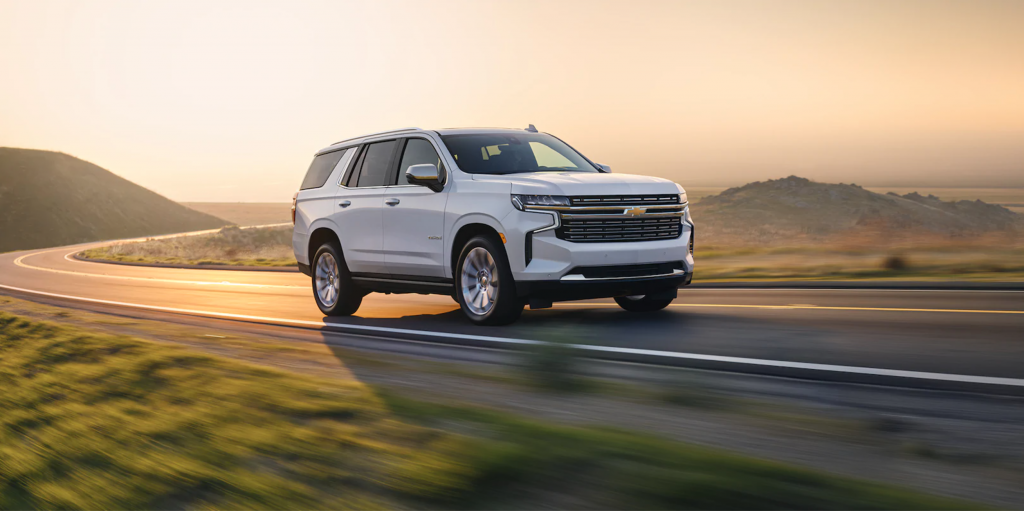 A white 2021 Chevy Tahoe driving at dusk