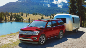 A red 2021 Ford Expedition towing an Airstream trailer