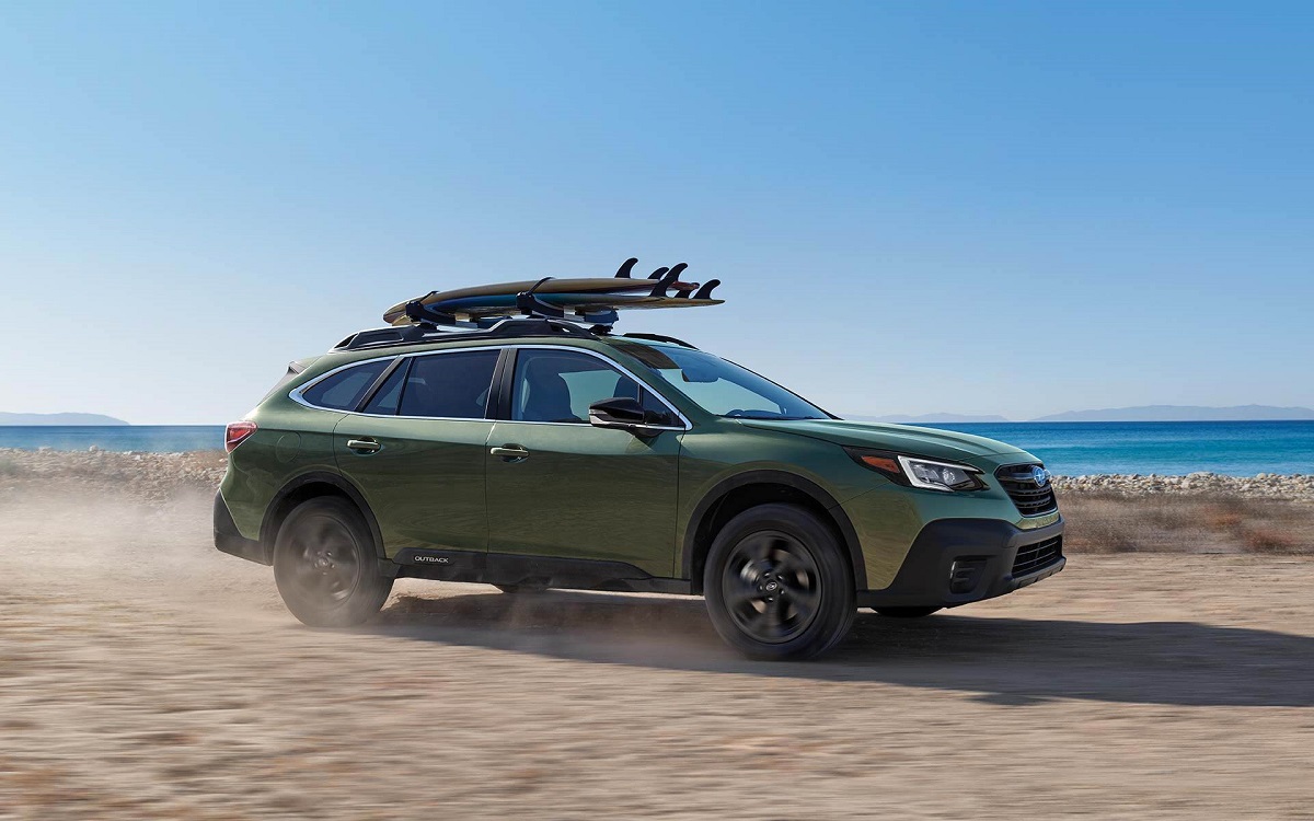 A 2021 Subaru Outback with surfboards strapped to it.