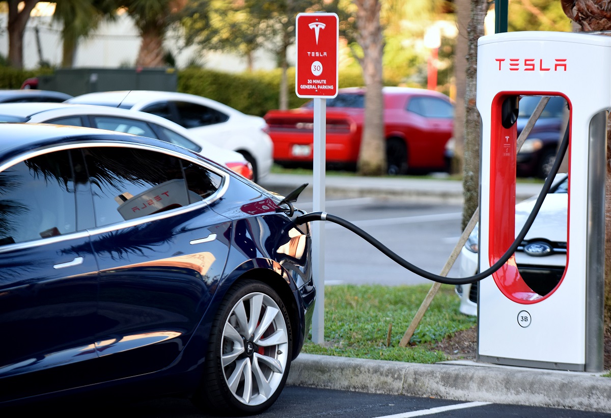 A black Tesla charging at a Supercharger.
