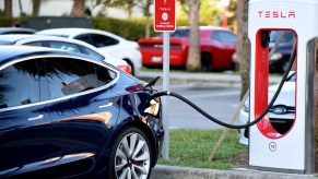 A black Tesla charging at a Supercharger.