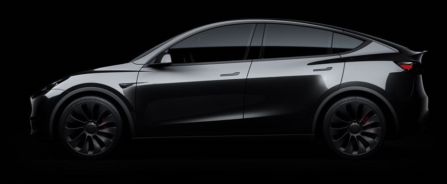 A dark gray Tesla Model Y against a black background.