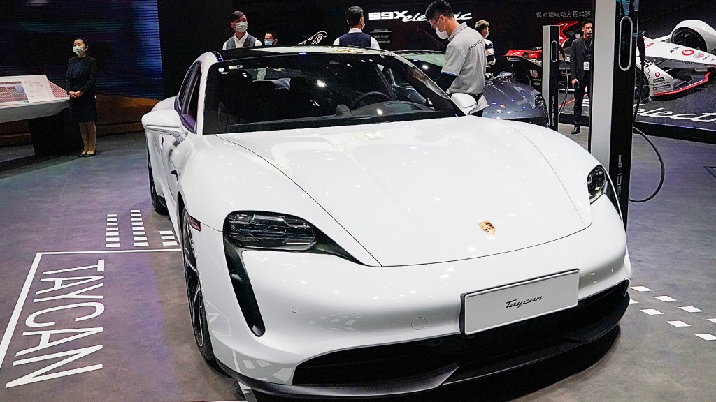 A white Porsche Taycan car is displayed during the 19th Shanghai International Automobile Industry Exhibition, also known as Auto Shanghai 2021, at National Exhibition and Convention Center.