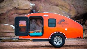 An orange Timberleaf Classic Teardrop Trailer parked, the Timberleaf Classic Teardrop Trailer is one of the coolest teardrop campers