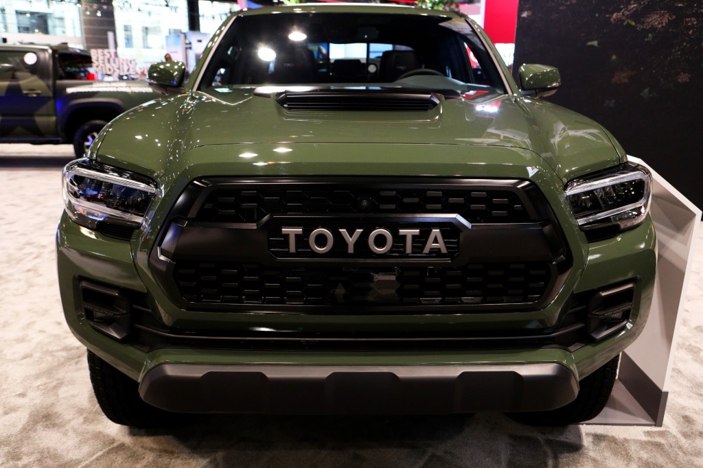 An army green 2021 toyota tacoma TRD Pro grille on display at an auto show 