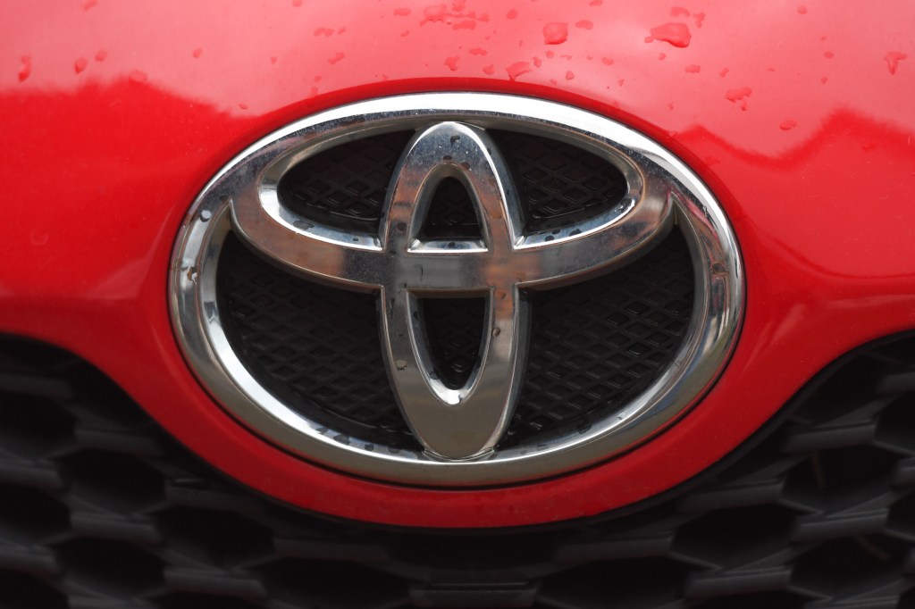 A silver Toyota logo on the front of a red vehicle