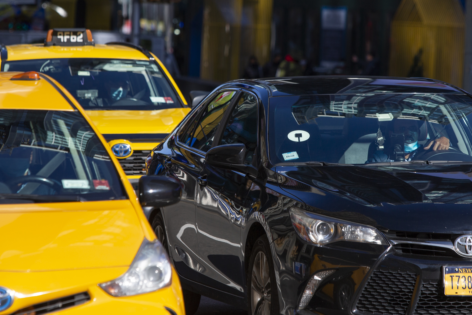 Yellow cabs and an Uber car drive through Times Square on November 16, 2020, in New York City