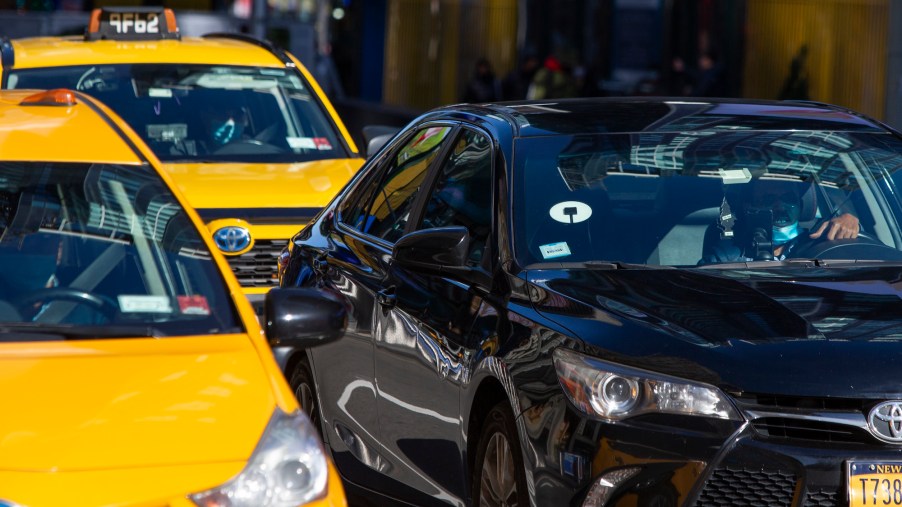 Yellow cabs and an Uber car drive through Times Square on November 16, 2020, in New York City