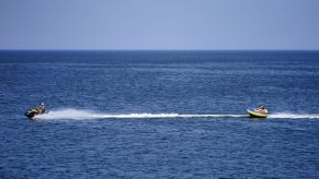 A tube being towed across the water from a jet ski