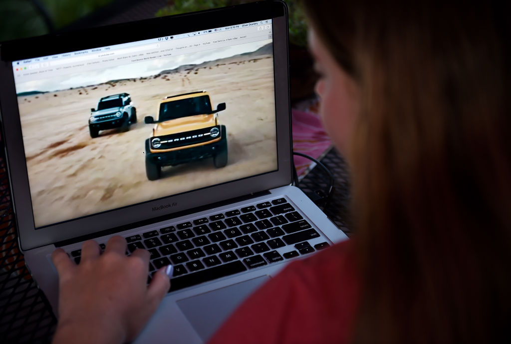 woman looking at Jeep and Bronco in her computer