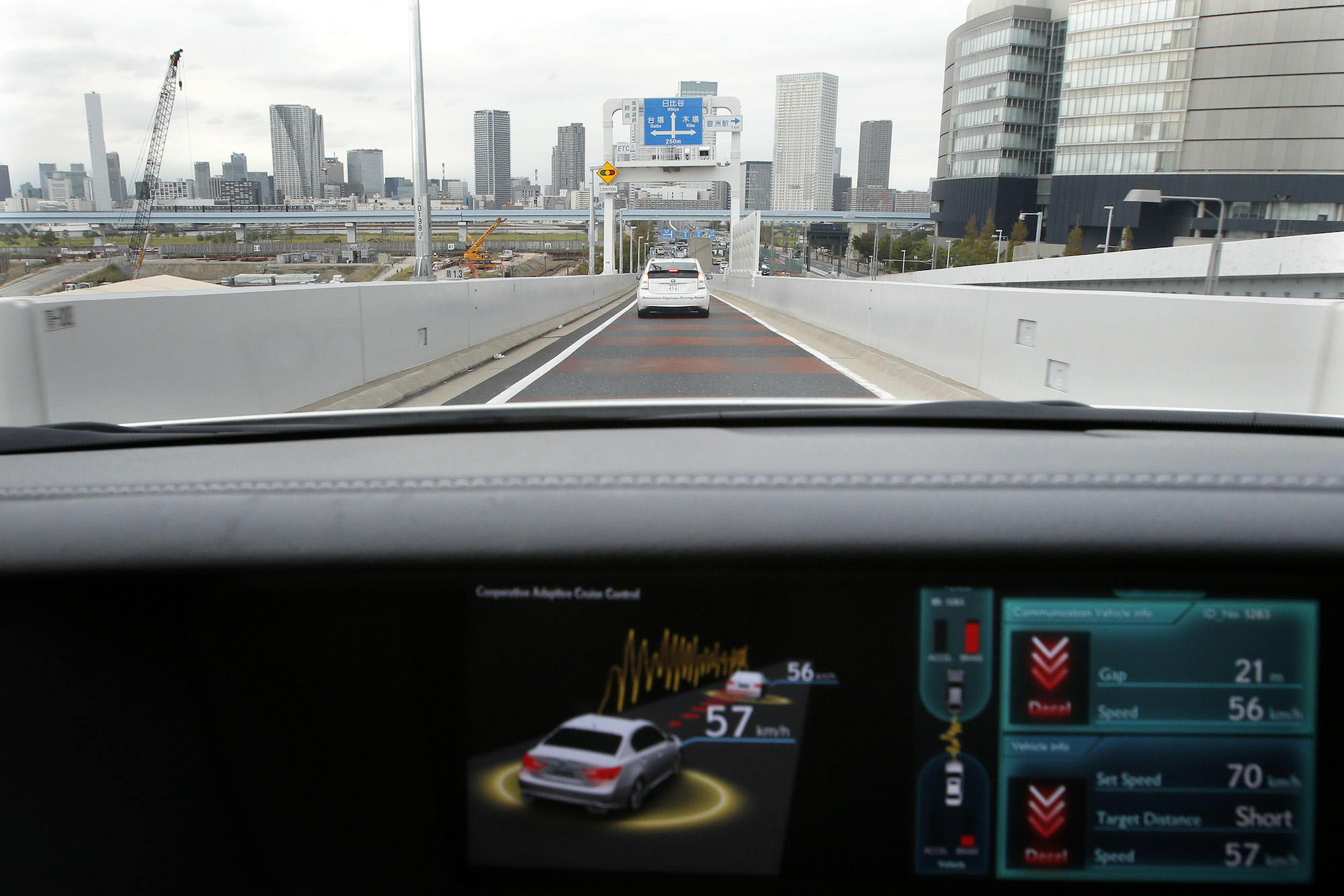 A view through a Lexus car's windshield as a monitor displays the status of the adaptive cruise contro