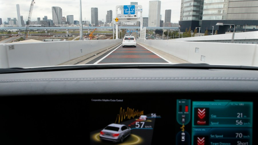 A view through a Lexus car's windshield as a monitor displays the status of the adaptive cruise contro