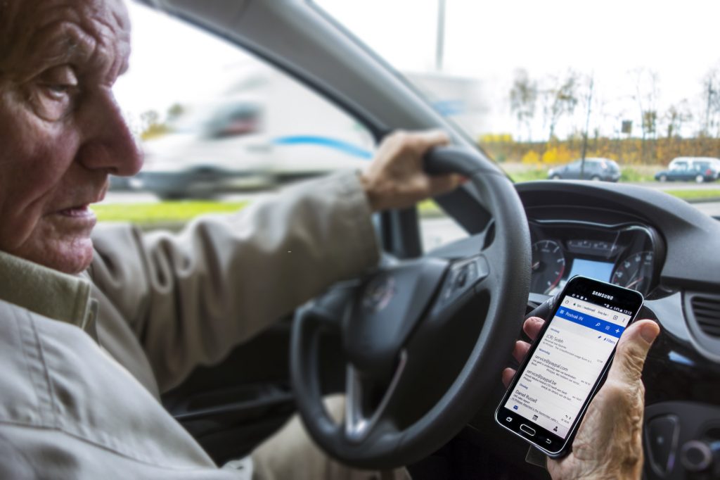 Scary driving habits including checking your phone messages while driving, like this man sitting behind the wheel of a car