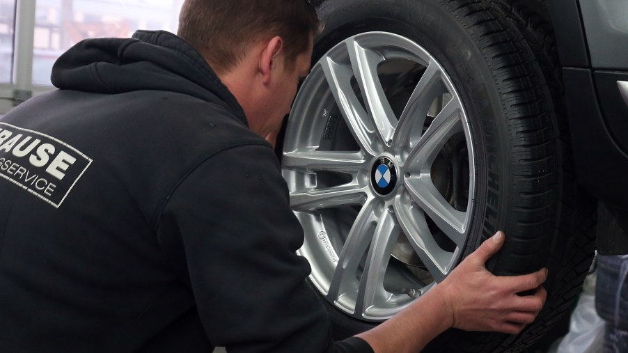A mechanic at a car repair shop changes a vehicle tire