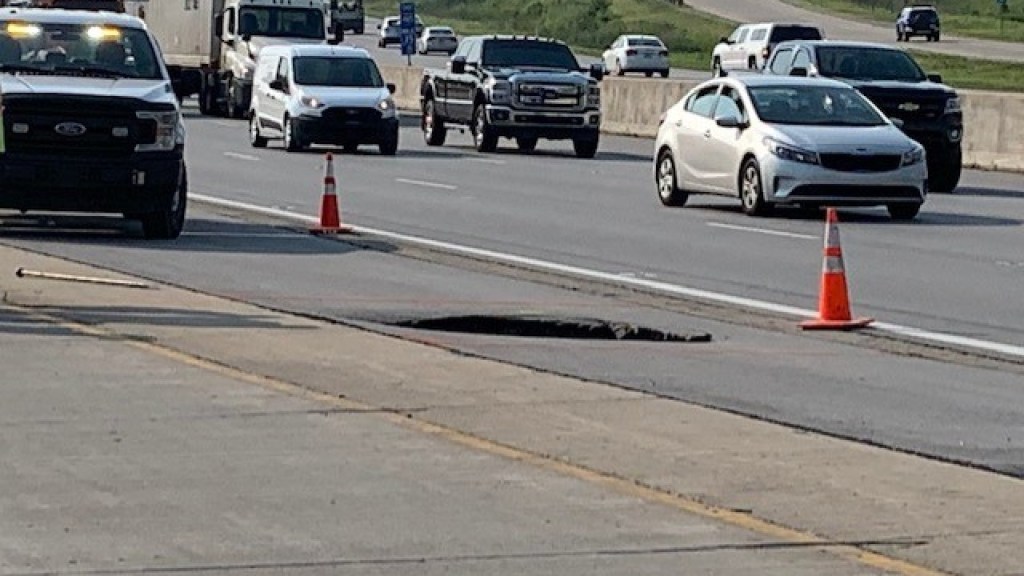 Traffic driving by a sinkhole on I-465