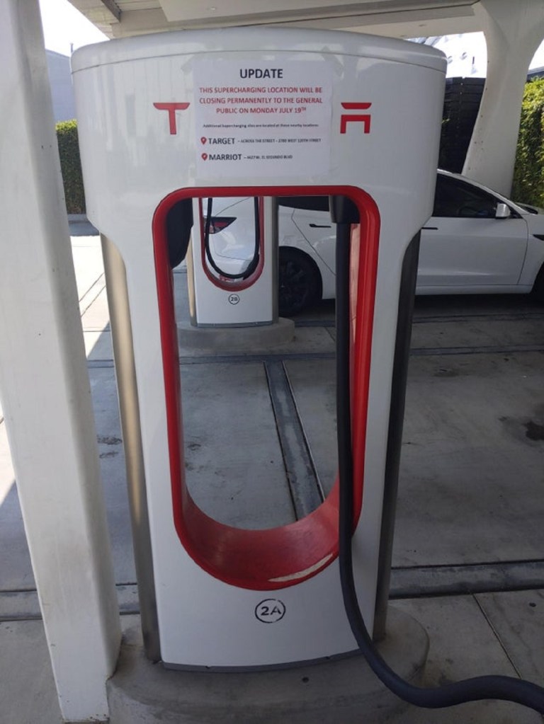 Tesla's first Supercharger site with a sign announcing its closure.