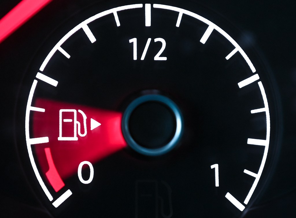 A car's fuel gauge points toward empty