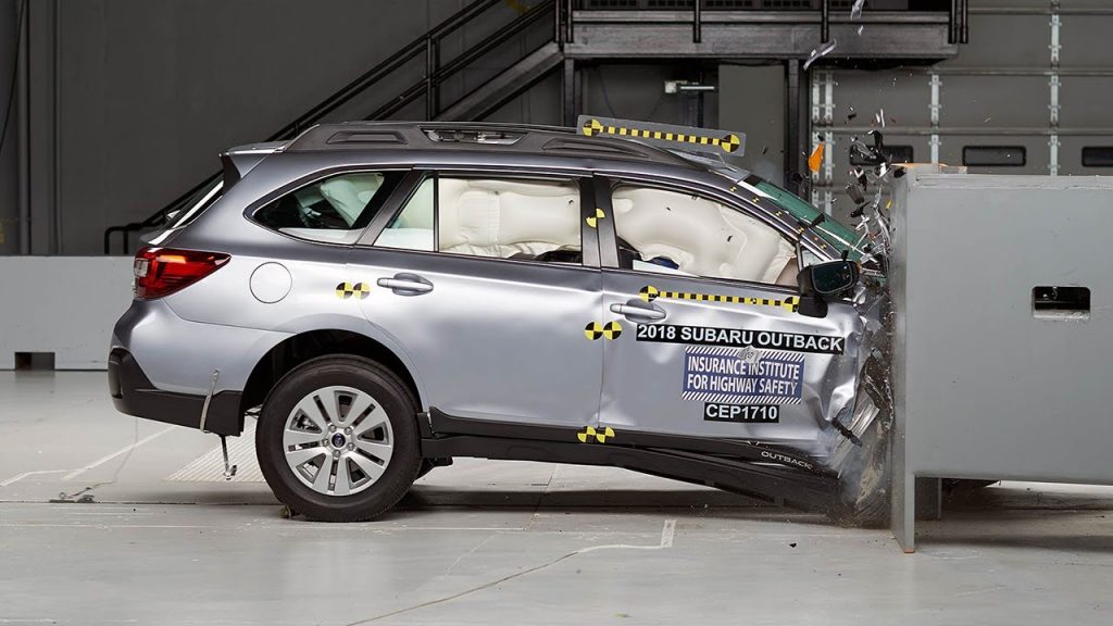 A silver Subaru Outback is crash-tested.