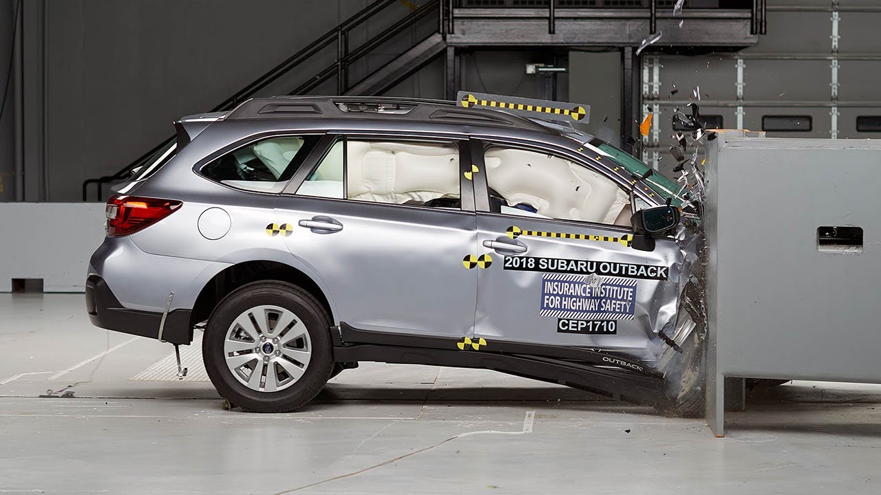 A silver Subaru Outback is crash-tested.