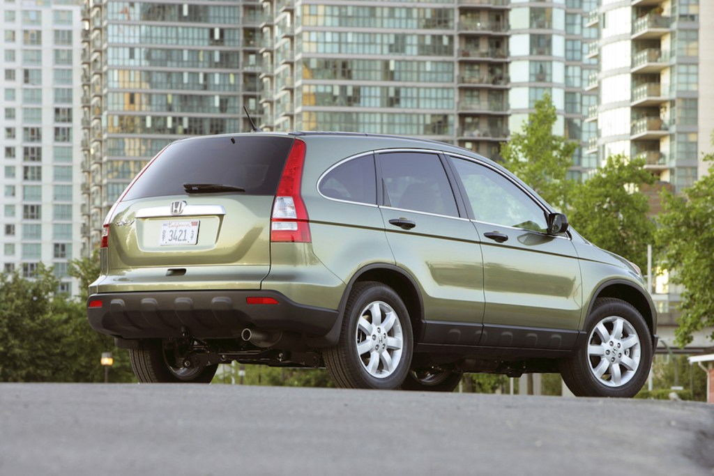 A rear quarter view of a green 2009 Honda CR-V parked in the city. 