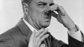 1950s 1960s MAN 3/4 PROFILE HAND HOLDING NOSE CLOSED HAND OUT TOWARD CAMERA FACIAL EXPRESSION DISGUST STINKING